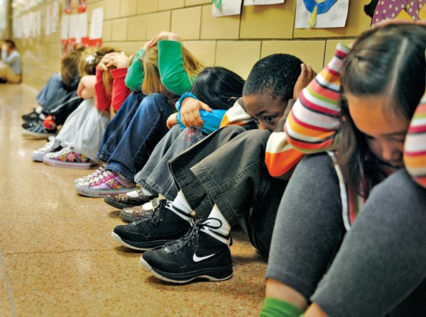 Students undergo a tornado drill at school. (Image via)