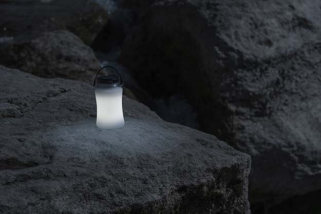 Stone Mountain AquaLight water bottle glowing in the dark on a rock.