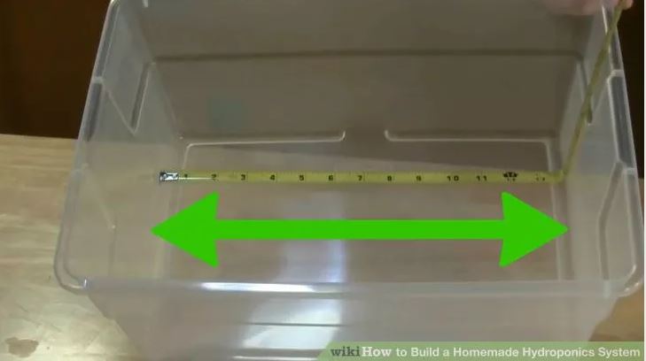 Measuring plastic bin with a tape measure