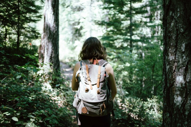 a girl carrying a backpack in the middle of the forest | Bug Out Bags For Women | best bug out backpack for women
