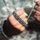 gray paracord rope soldier hand parachute | Cutting Paracord Without A Knife | featured