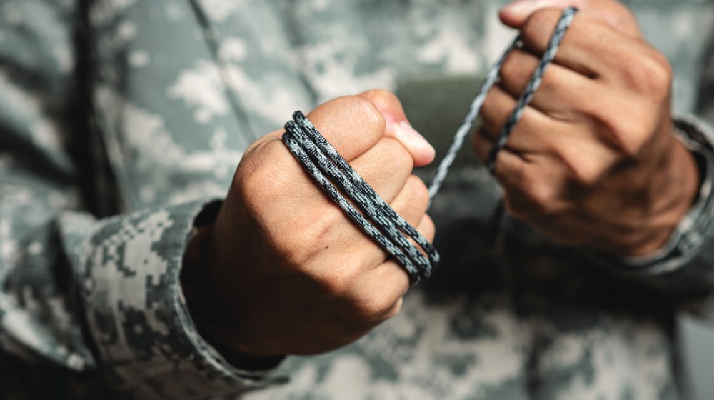gray paracord rope soldier hand parachute | Cutting Paracord Without A Knife | featured