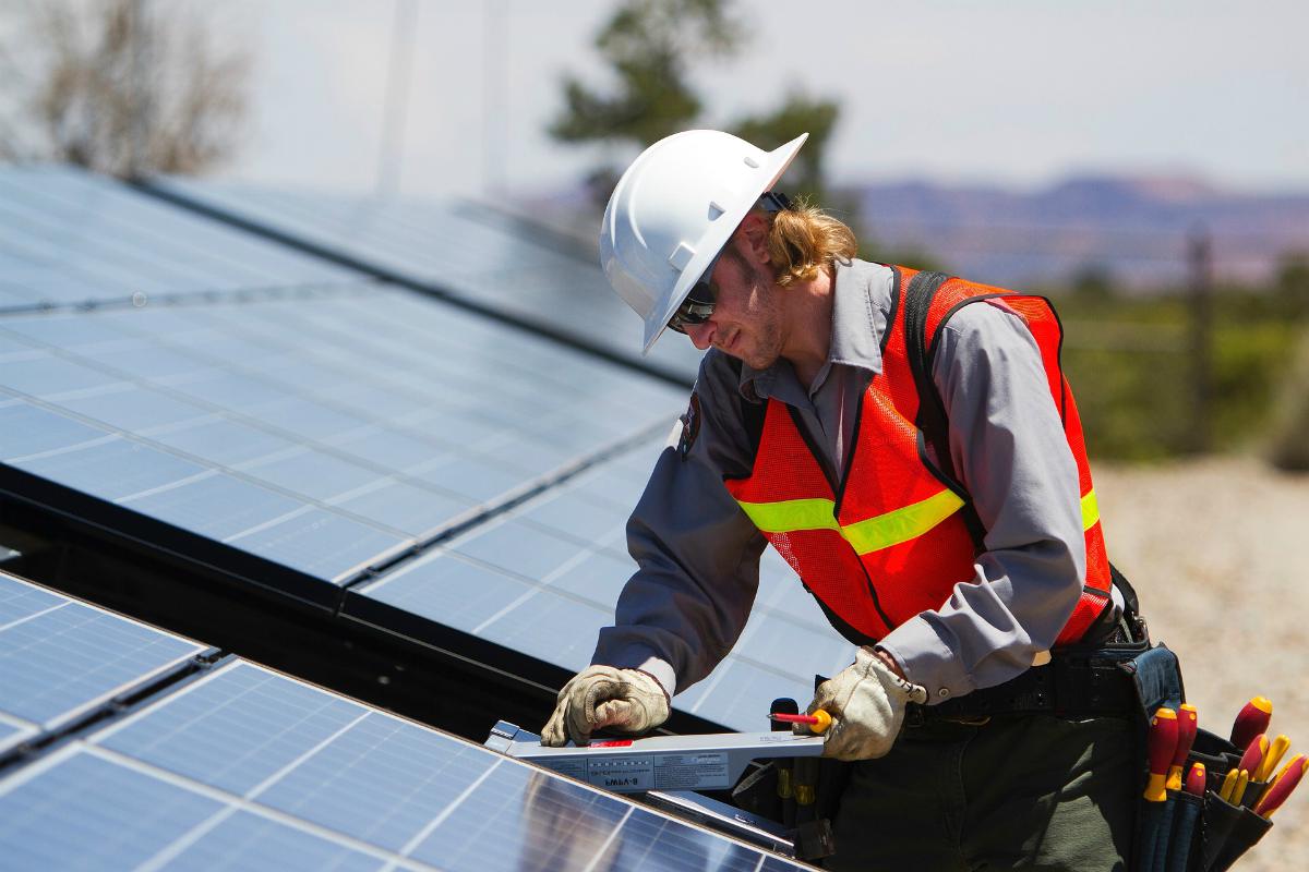 Male technician installing battery in blue solar panel | DIY Solar Power - Part 2
