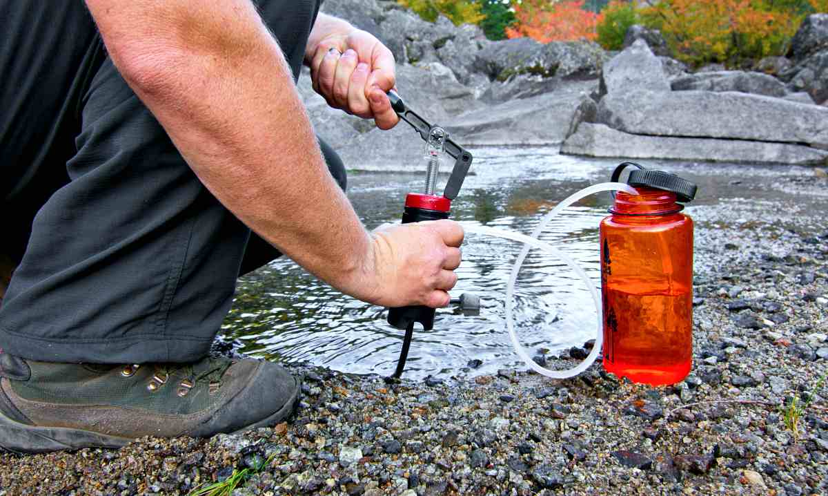 A person uses a lightweight compact water filter to pump safe drinking water | How To Make A DIY Pocket Water Filter [Video] 