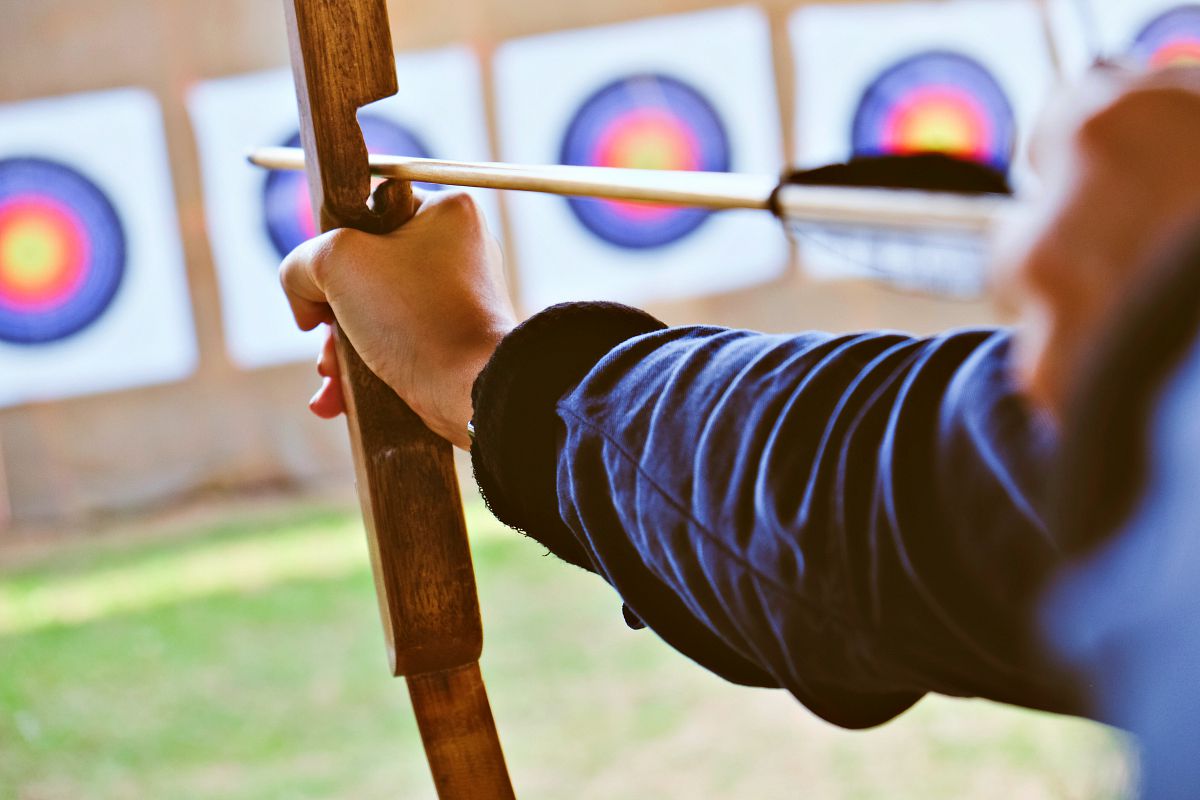 Archer holds his bow aiming at a target | Archery 101: Tips And Tricks For Beginners 