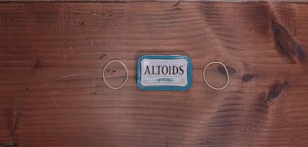 Step 1: Start with an  empty Altoids tin and two rubber bands to hold the tin shut | How To Build The Perfect Pocket-Sized Survival Kit