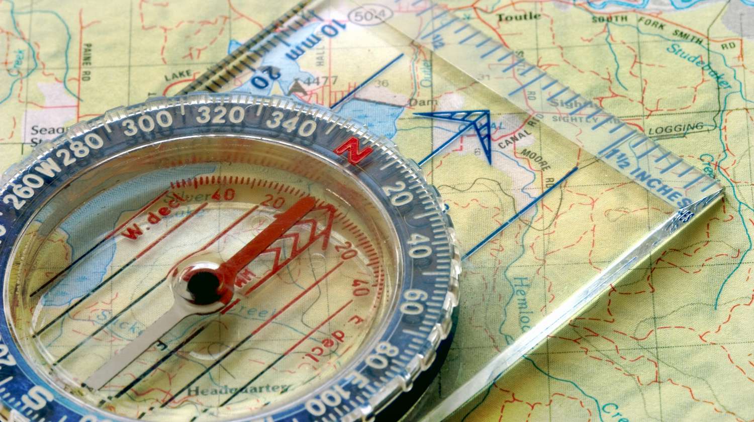 Close-up view of a compass sitting on a topo map | USGS Topo Maps Of Every Quad In The Continental US [Free Printable] | Featured