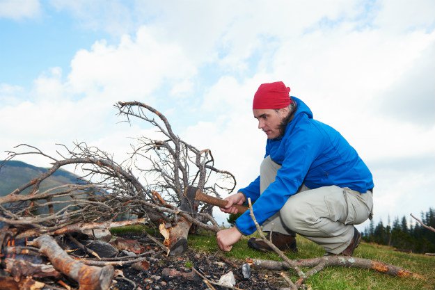 man-collecting-fire-wood How To Start and Maintain a Fire in a Winter Survival Situation