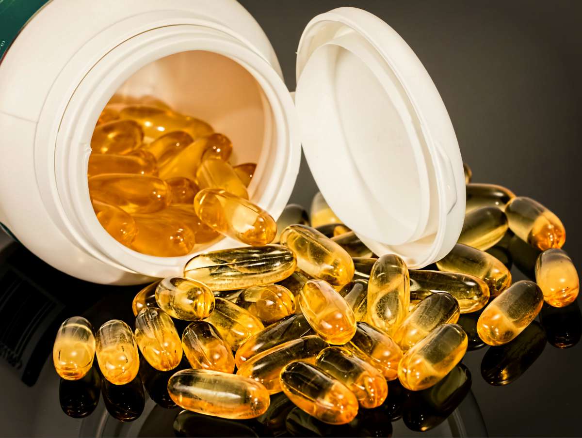 Yellow capsules on the table | Best Vitamins For Men & Women And OTC Medicines To Stock Up On