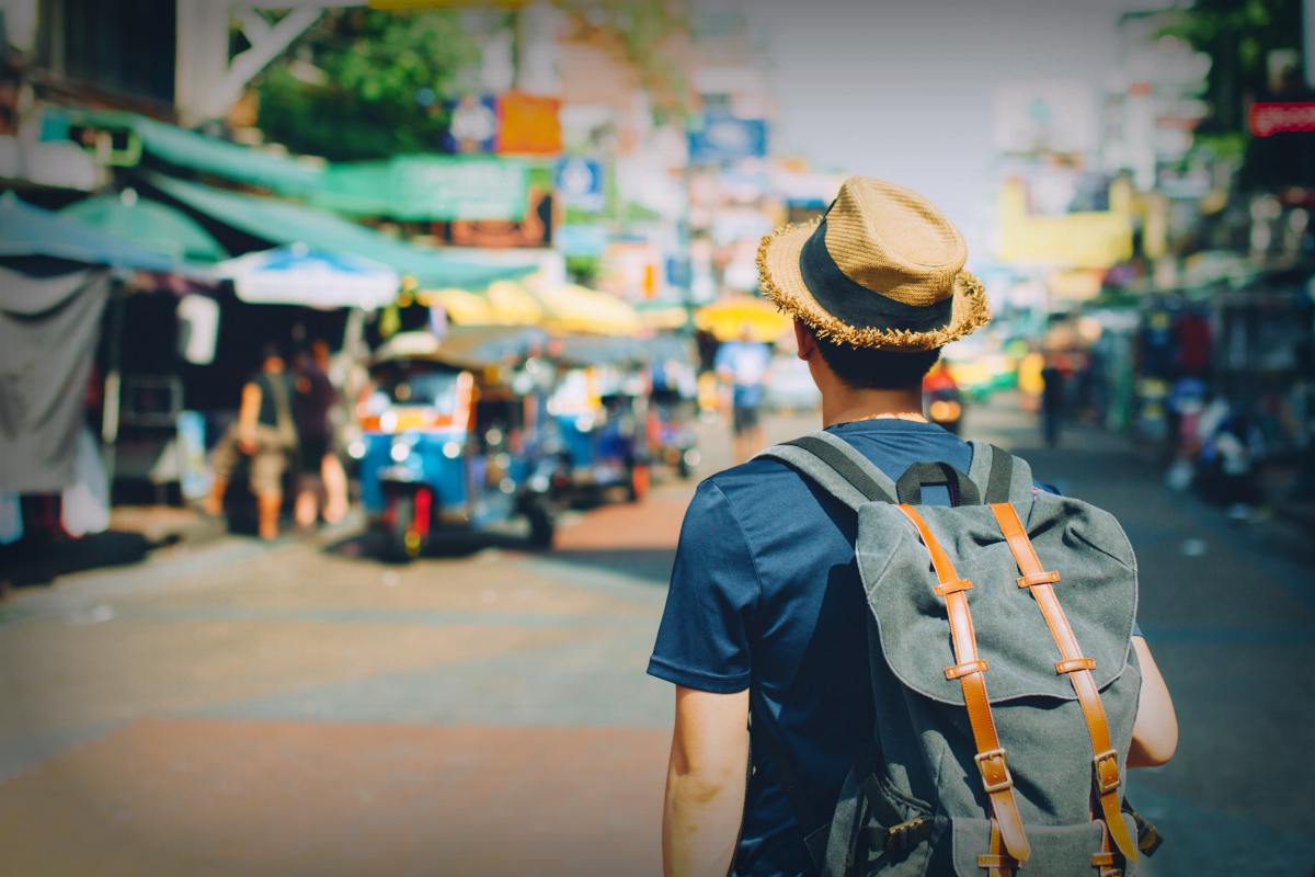 Young Asian traveling backpacker in Khaosan Road outdoor market | Travel Safety Tips You Shouldn't Ignore