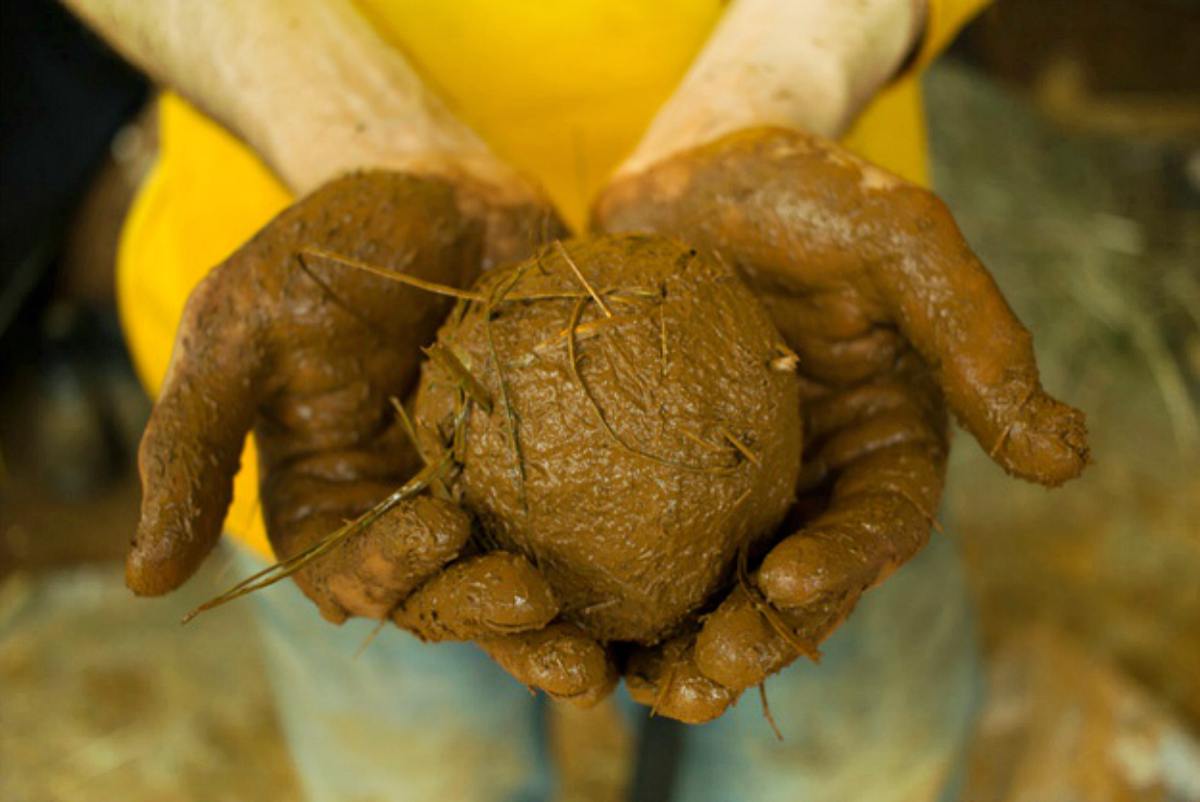 Holding ball of mud | How To Make Homemade Survival Cement