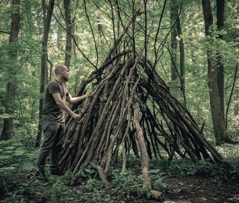 man-building-survival-shelter-forest-woods survival hacks 