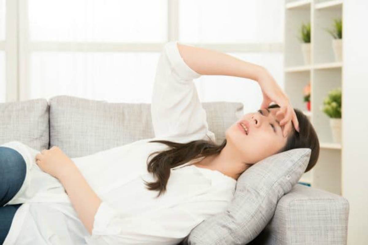 Woman having migraine on sofa | Heart Attack Signs You Should Know To Survive When You Are Alone