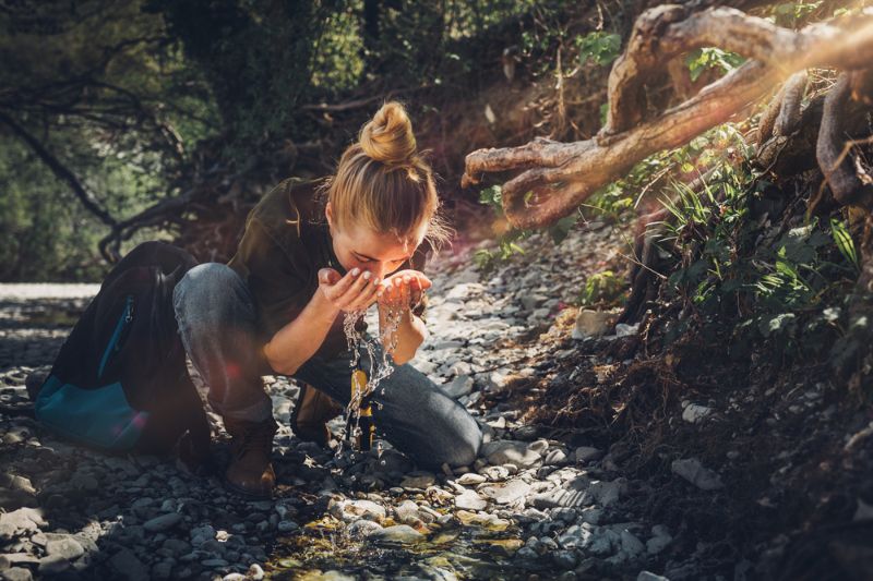 young-woman-washes-her-face-mountain survival hacks 