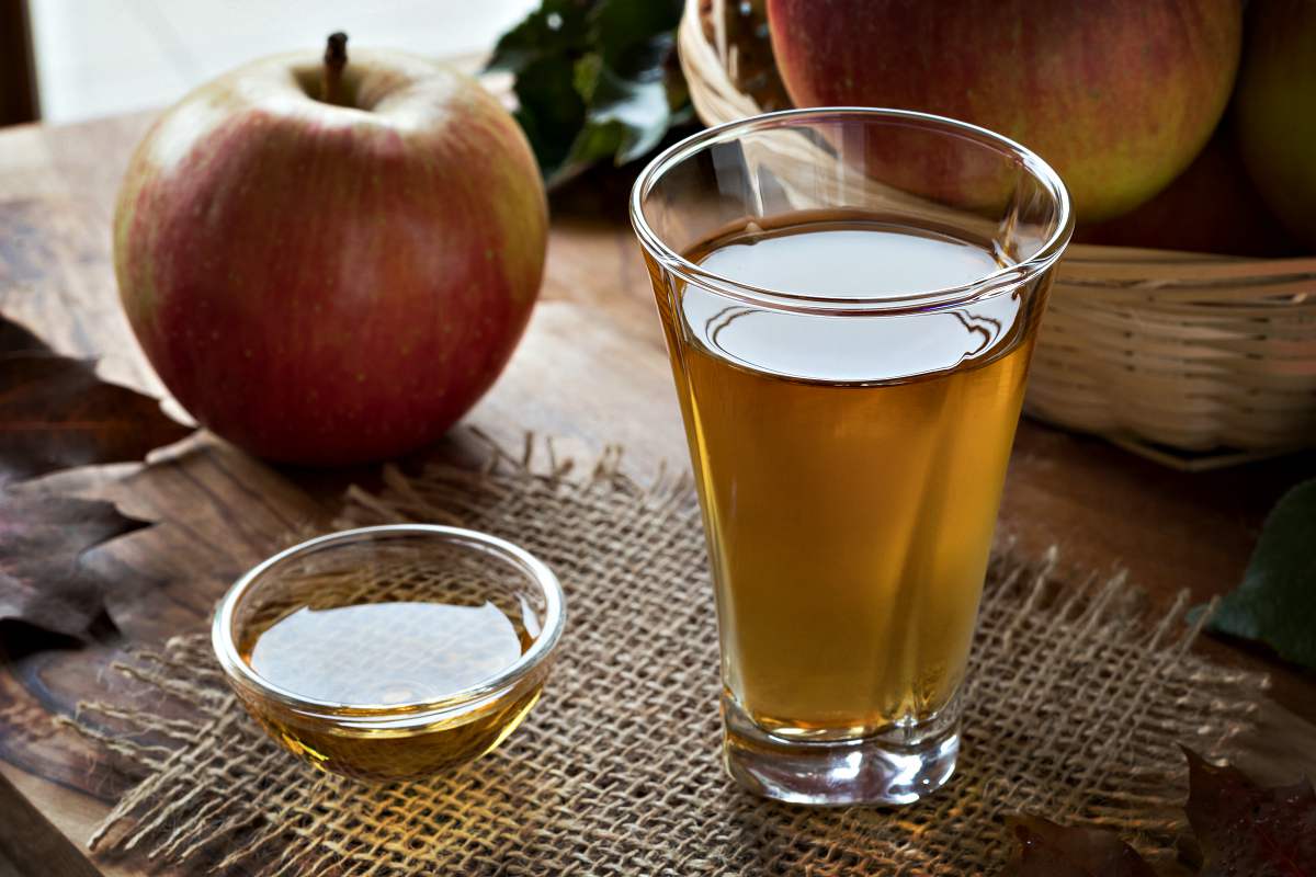 Apple cider vinegar in a glass, with apples in the background | Chicken And Duck Keeping | Top Natural Remedies For Your Sick Flock