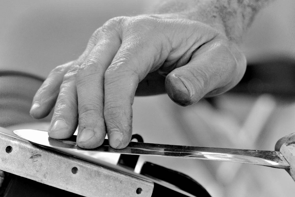 Grayscale image of a man hand sharpening knife | Knife Sharpening Made Easy