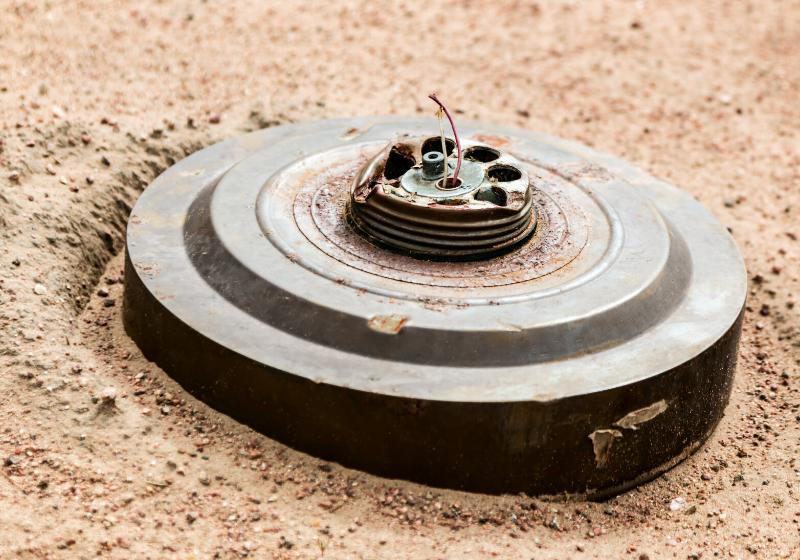 old anti-tank mine buried in the desert sand | best homemade weapons