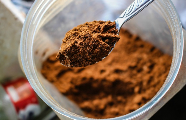 brown cocoa powder on a stainless spoon Cocoa Powder | Top Beard Wash Ingredients and What They Do