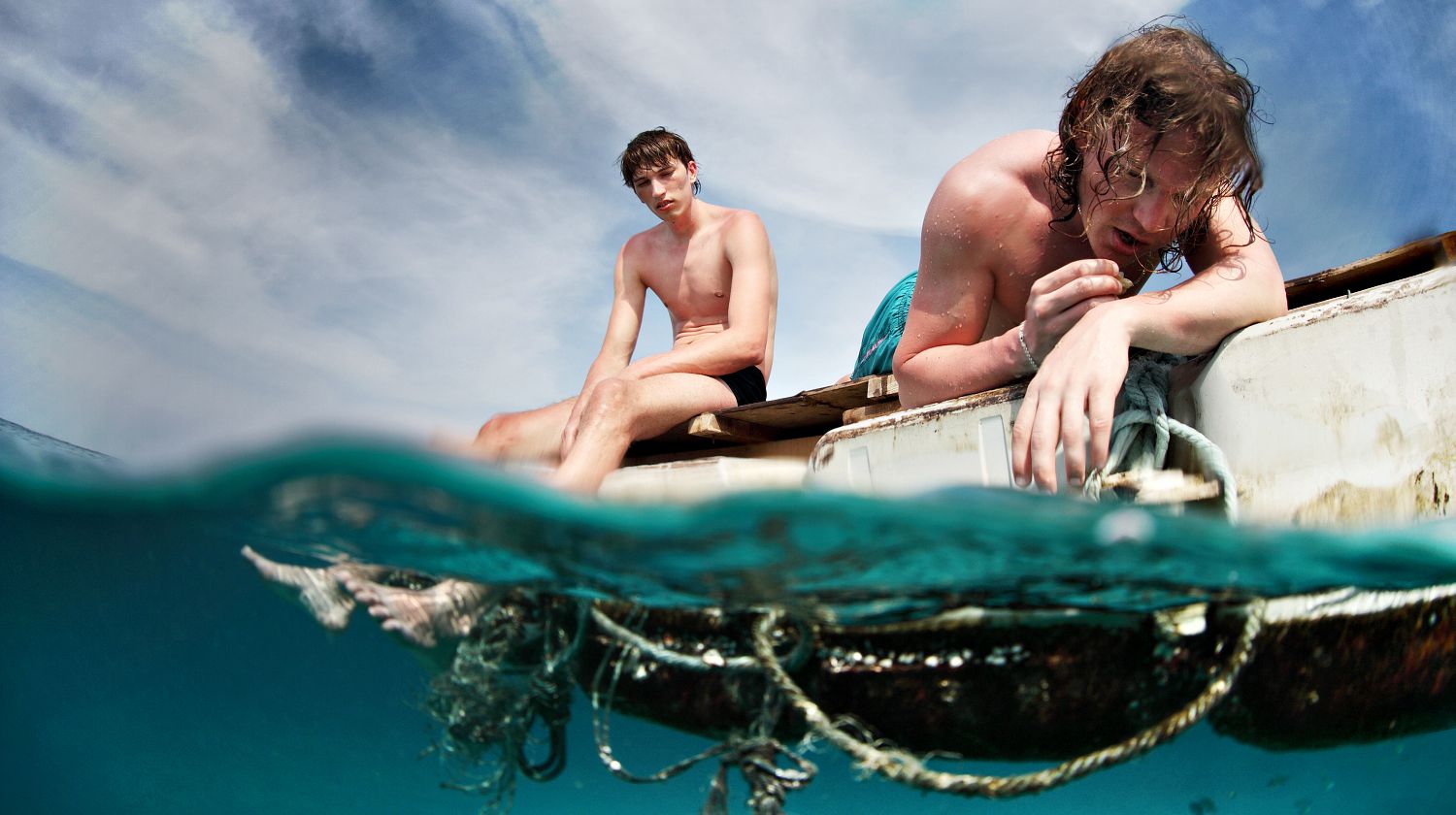 Featured | Two men floating in a sea with sad faces | Lost At Sea Survival Guide | Tips And Tricks For Ocean Navigation