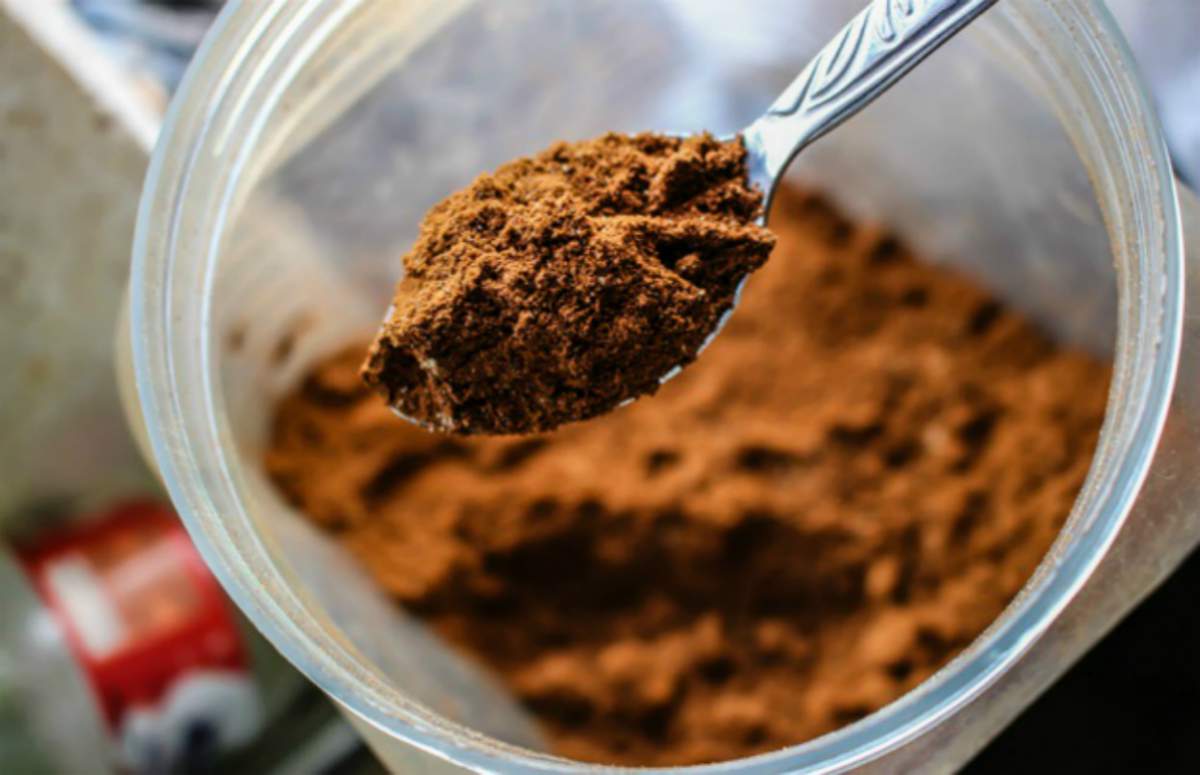 brown cocoa powder on a stainless spoon Cocoa Powder | Top Beard Wash Ingredients and What They Do