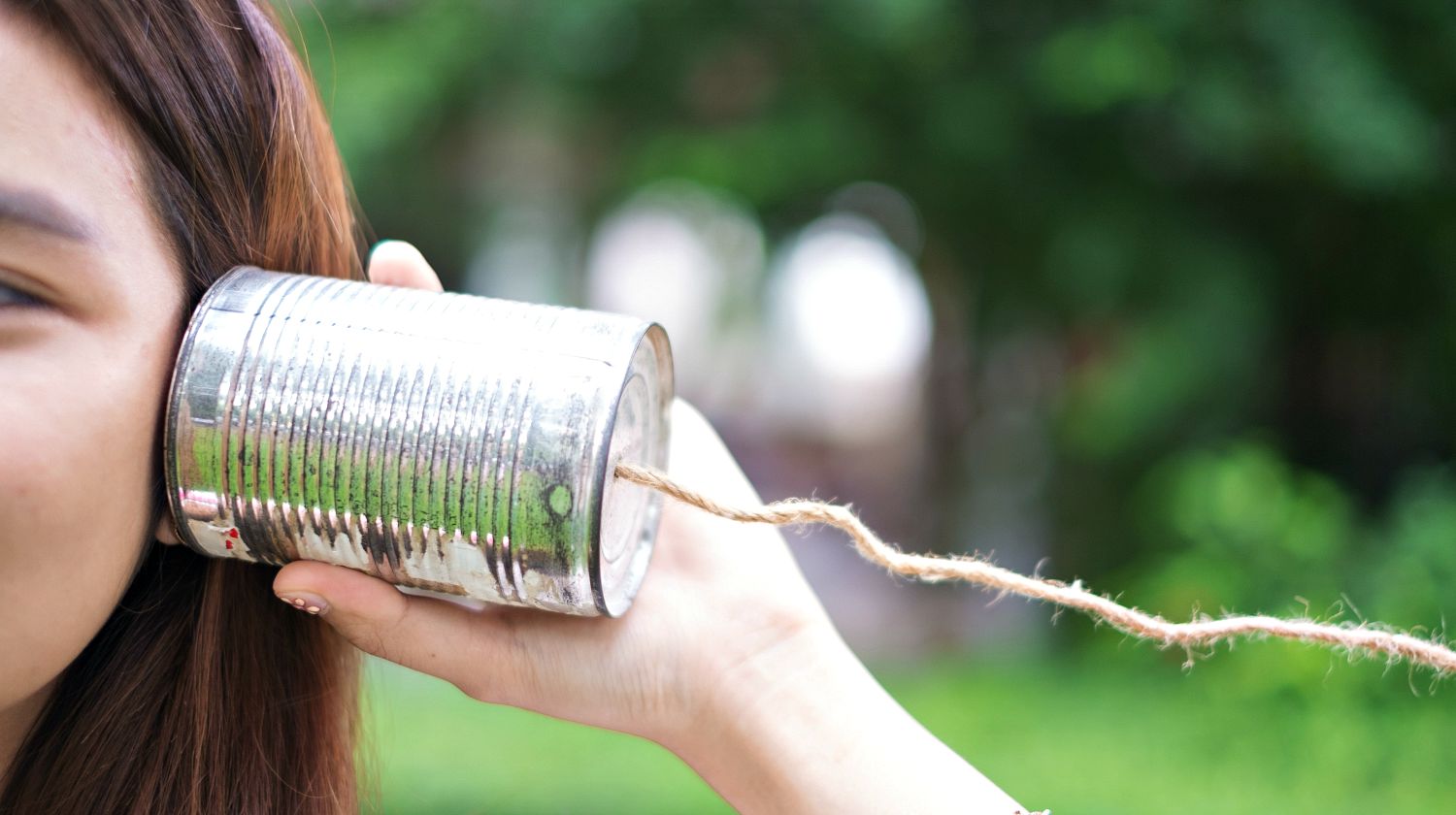 A girl listening through the tin can telephone | Surprising Survival Uses For A Tin Can | Featured