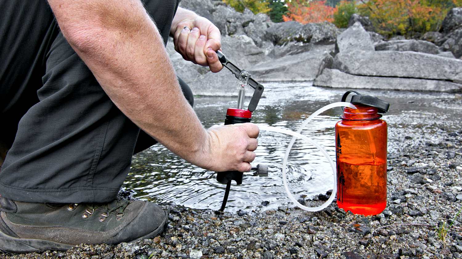 Hiker filtering water from stream | How To Purify Water | Water Decontamination Techniques | Featured