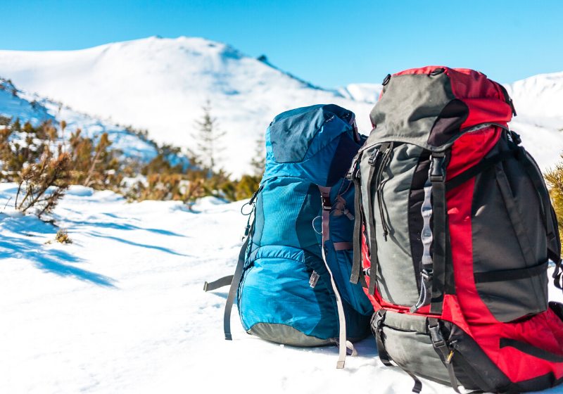 two backpacks background snowcapped mountains blue | survival supplies