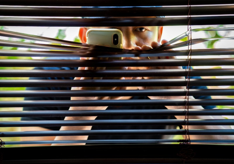man sneaking venetian blind | home safety articles