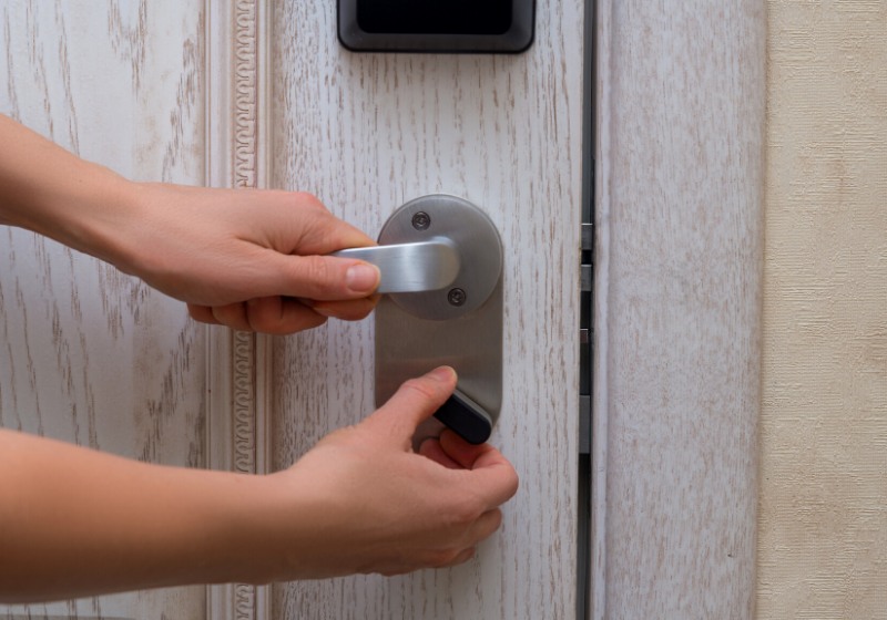 woman closes door lock deadbolt | home safety hazards