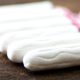 clean white tampons lying on wooden | Surprising Survival Uses for a Tampon | featured