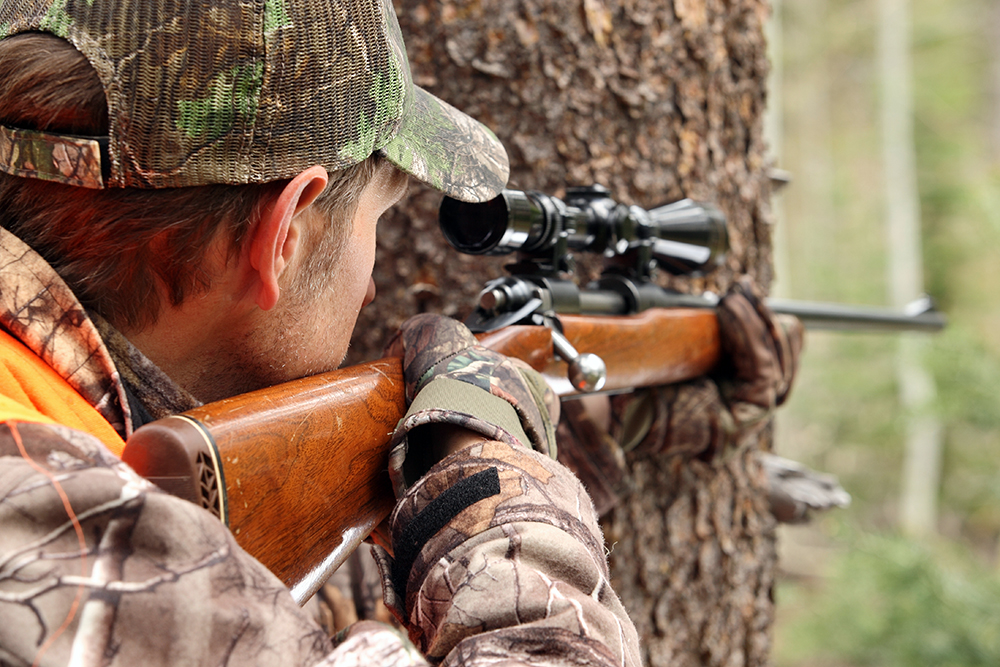 guy holding a rifle | Deer Hunting For Beginners: How To Get Started