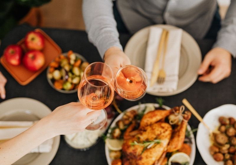 Food on the table with two people having wine | surviving christmas with the relatives