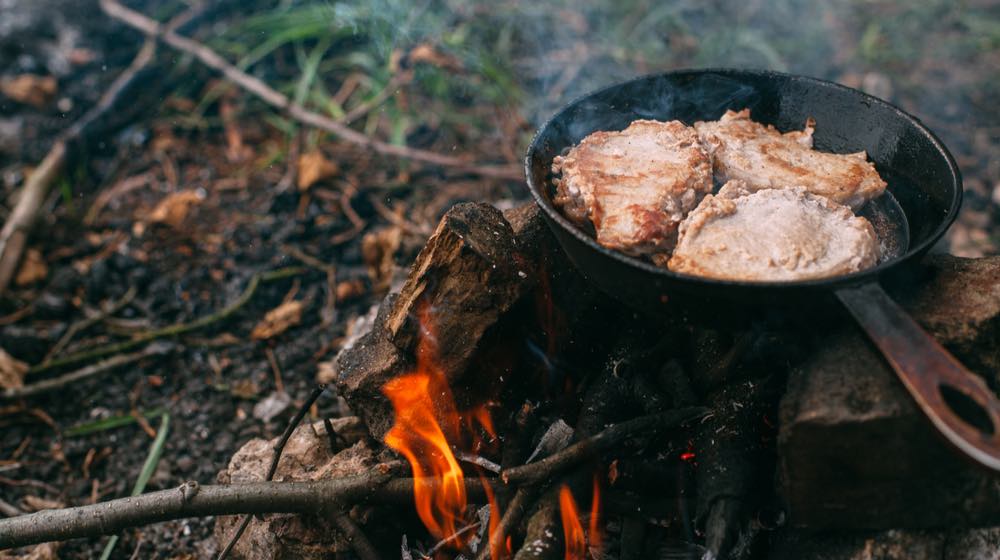 Steak in a pan on a fire. Cooking in nature. Picnic. Grill on fire | Campfire cooking