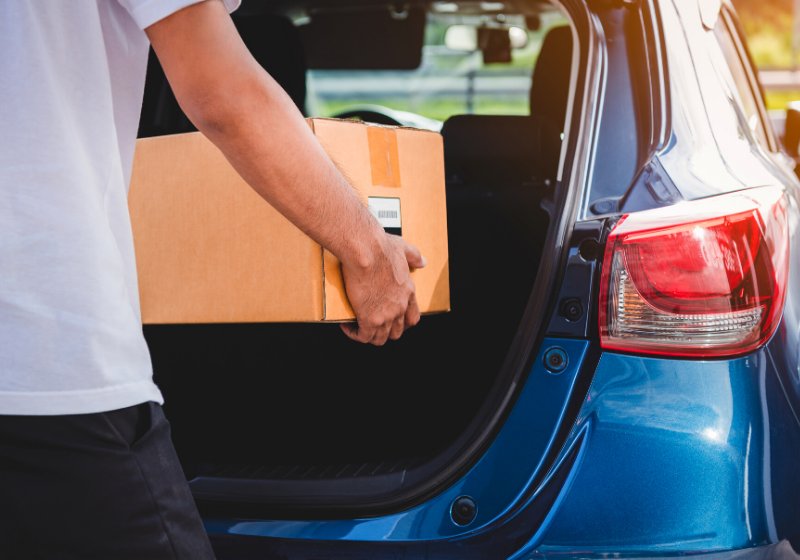 delivery man delivering cardboard box customers | living in your car hacks