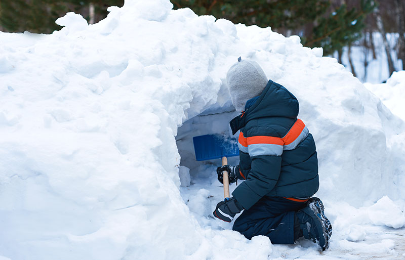 european boy making snow cave | how to build a quinzee