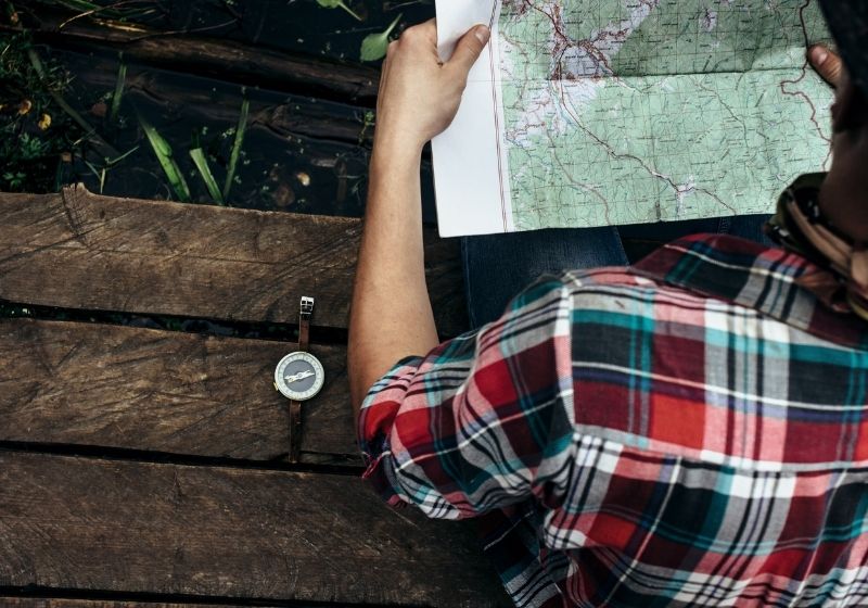 Stylish hipster traveler exploring map Car camping SS