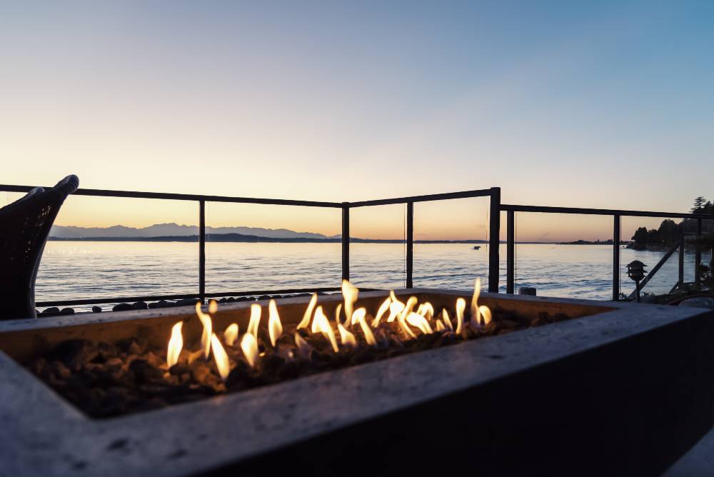 Sunset in the backyard by the fire pit and the sea | How to Choose the Best Propane Fire Pit for You | Top 9 Propane Fire Pits on the Market | featured