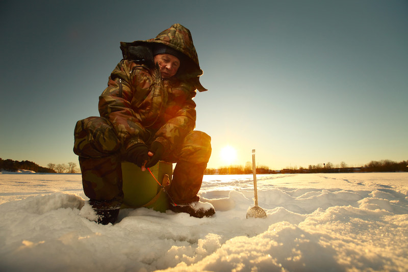 Fisherman on a lake at winter sunny day | ice fishing tips for perch