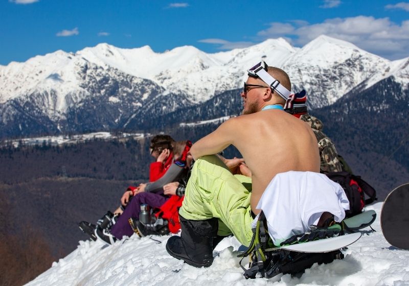 Snowboarder sitting topless at the snowy mountaintop First aid guide SS