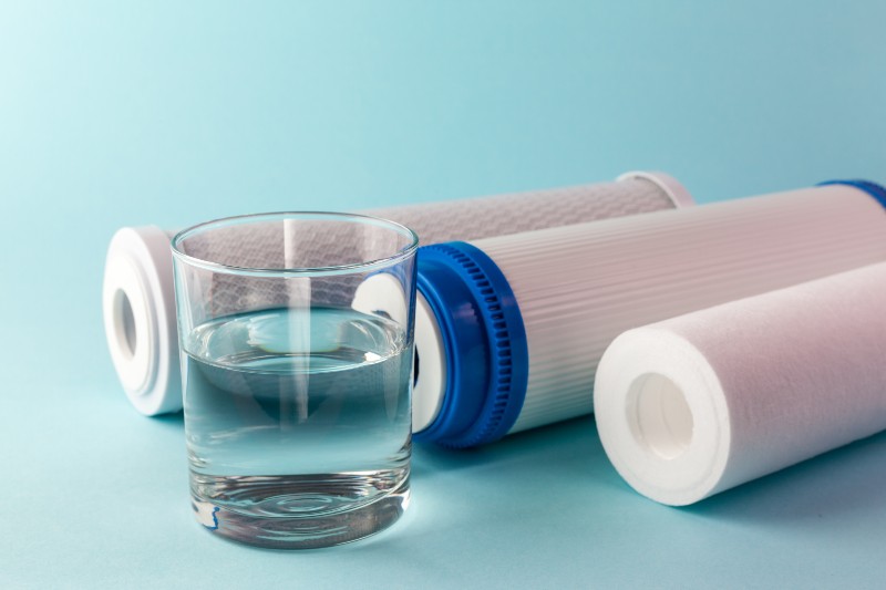 A glass of water on the background of filter cartridges-Water Filter