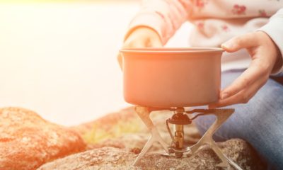 Women's hands hold a saucepan on a gas burner-Wild Survival Foods-ss-featured
