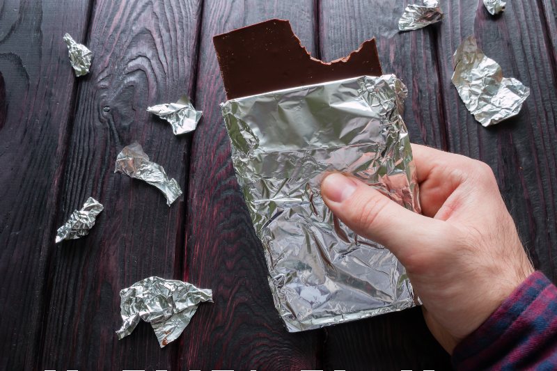 man eating a bar of chocolate on a black background-Food Kit-SS