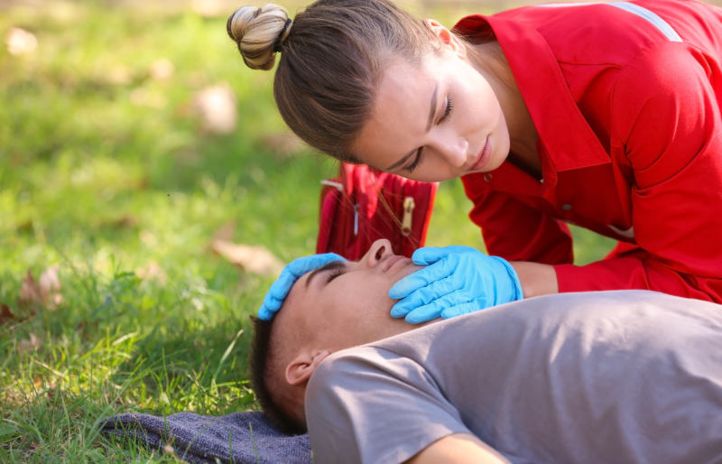woman uniform checking breathing unconscious man | wilderness first aid