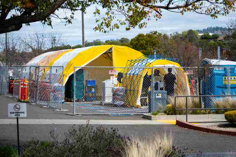 A yellow tented area in construction outside of Sutter Auburn Faith Hospital | Emergency Shelters