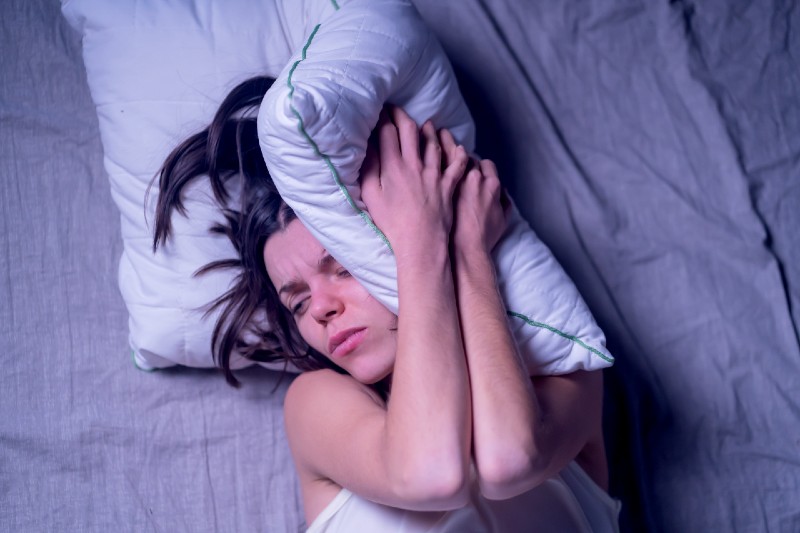 A young girl woke up in the morning in bed with a severe headache after the stress at work and nerves | Neurogenic Shock