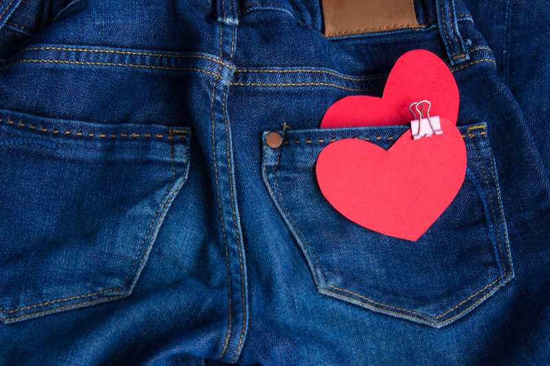 Blue jeans pants with hearts in back pocket. Valentines Day concept-binder clips