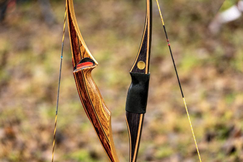 Close-up of two archery bows made of wood called longbow on a blurred landscape-diy bow and arrow