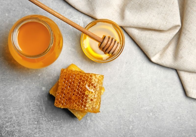 Delicious honey and fresh honeycombs on table Foods to stock up on SS