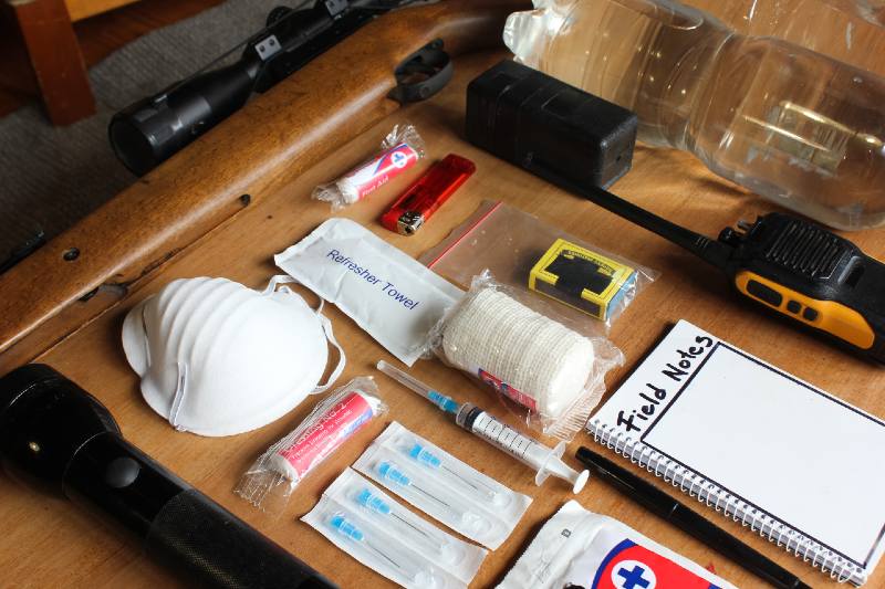 Emergency evacuation survival grab bag gear or items displayed on a wooden table | Scenario Two – Prepared Family