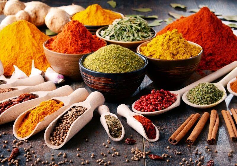 Variety of spices and herbs on kitchen table Foods to stock up on SS